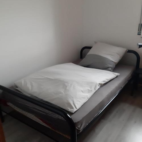 a bed with white sheets and pillows on it at Ferienwohnung Feldblick in Isernhagen