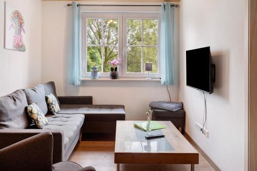 a living room with a couch and a table and a window at Ferienhaus Heerlichkeit in Löffingen
