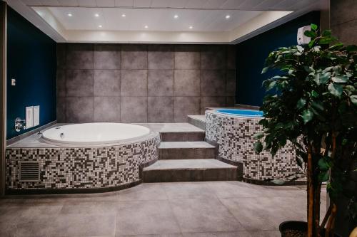 雷訥瑟的住宿－Hotel de Zeeuwse Stromen - Duinpark，带浴缸、楼梯和浴缸的浴室