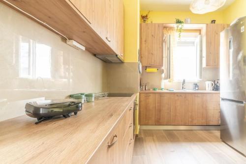 a large kitchen with wooden cabinets and a counter top at Bohemian City Home near Centre in Thérissos