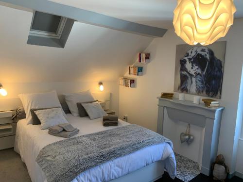 - une chambre avec un lit et une photo d'un chien sur le mur dans l'établissement Maison 6 pers Elle est Moi, à Romorantin-Lanthenay