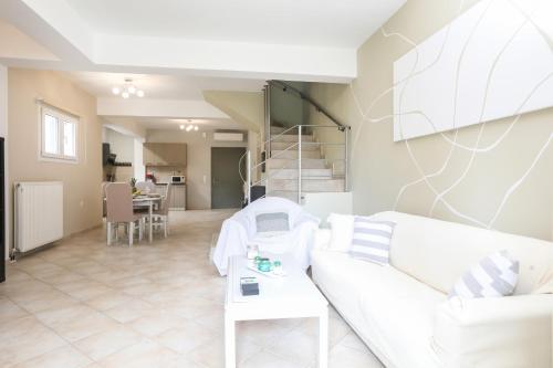 a living room with a white couch and a table at Martzon House Corfu in Kynopiástai