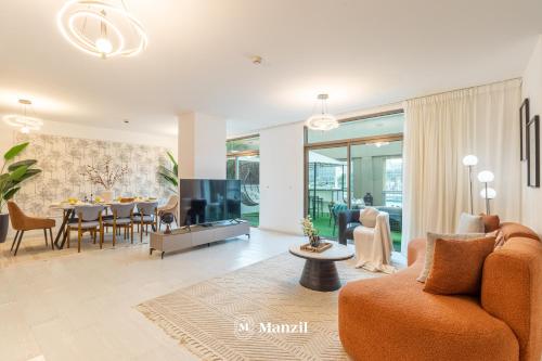 a living room with a couch and a dining room at Manzil - Luxury 3BR Villa w/ maid room, Full Burj & Fountain view in Dubai