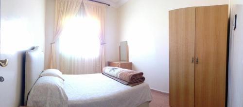a bedroom with a bed and a large window at Maison d'hôtes afoulki tafraout in Tafraoute