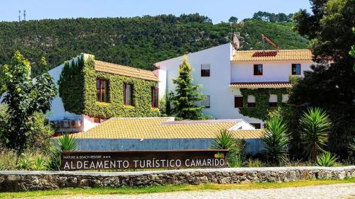 a building with a sign in front of it at Nature & Beach Guest Rooms, Aldeamento Turístico do Camarido in Cristelo