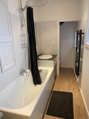 une salle de bain avec une baignoire et un lavabo dans l'établissement Appartement centre-ville, à Saulieu