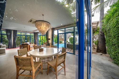 a dining room with a table and chairs at Aleenta Hua Hin - Pranburi - The Small Luxury Hotels of the World in Pran Buri