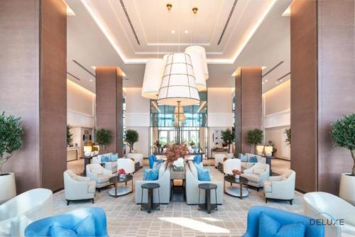 a lobby of a hotel with couches and chairs at Seafront 4BR Apartment with Assistant Room in The Address Fujairah Residences Block B, Fujairah by Deluxe Holiday Homes in Fujairah