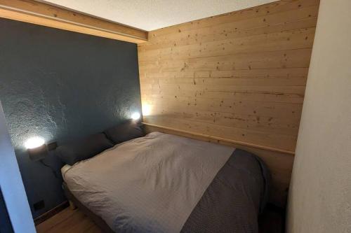 - un petit lit dans une chambre avec deux lumières dans l'établissement Location appartement montagne, à Châtel
