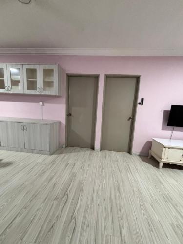 an empty room with pink walls and wooden floors at Putatan Platinum Apartment in Kota Kinabalu
