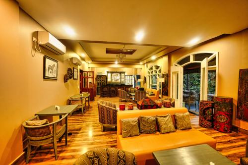 a living room with a couch and tables at The Atman Dharamshala by Leisure Hotels in Dharamshala
