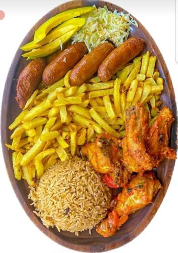 a plate of food with sausages rice and vegetables at Occazia Hotel in Mbarara