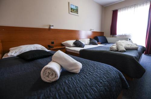 a hotel room with two beds with towels on them at Hotel Zagi in Oroslavje