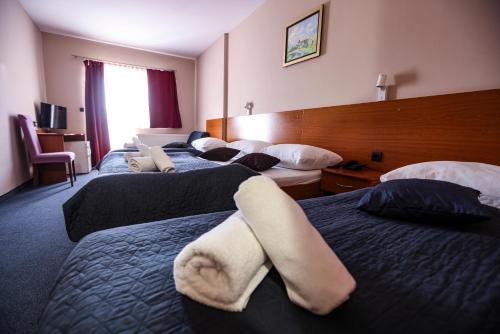 a hotel room with three beds with towels on them at Hotel Zagi in Oroslavje