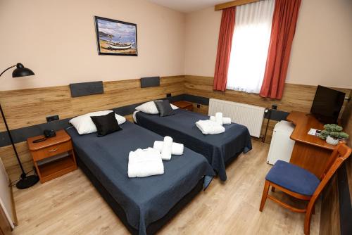 a hotel room with two beds and a television at Hotel Zagi in Oroslavje