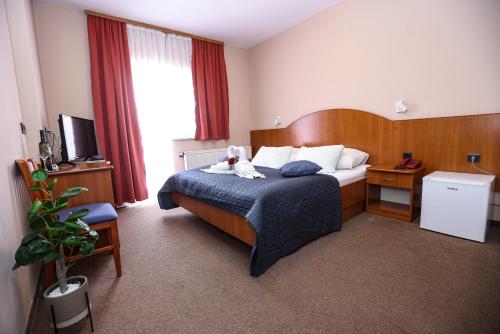 a hotel room with a bed with a teddy bear on it at Hotel Zagi in Oroslavje