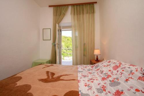 a bedroom with a bed with a quilt on it at Apartmány Viktor in Selca kod Bogomolja