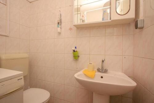 a white bathroom with a sink and a toilet at Apartmány Viktor in Selca kod Bogomolja