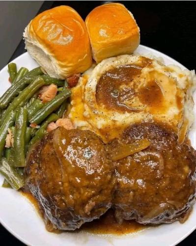 a plate of food with meat and green beans and bread at Occazia Hotel in Mbarara
