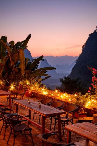 a group of tables and chairs with lights at Yangshuo Yunshe Mountain Guesthouse in Yangshuo