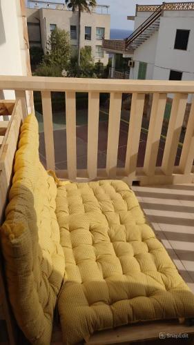 a yellow bed sitting on a balcony at Apartamentos Can Salas in Cala Figuera