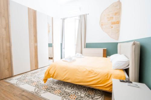 a bedroom with a bed with a yellow blanket at La Pinta in Mola di Bari