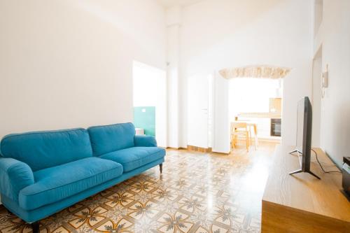 a blue couch in a living room with a tv at La Pinta in Mola di Bari