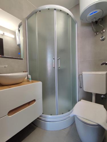 a bathroom with a shower and a toilet and a sink at Guest House Exalto in Trogir