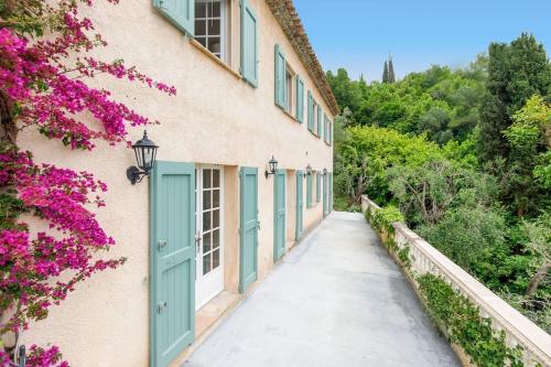 a corridor of a building with blue doors and flowers at Bastide Provençale,Piscine in Cabris