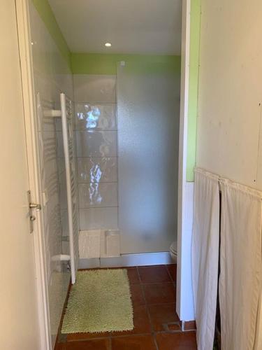 une douche avec une porte vitrée dans une salle de bain dans l'établissement Vert Luisant, aux Issambres