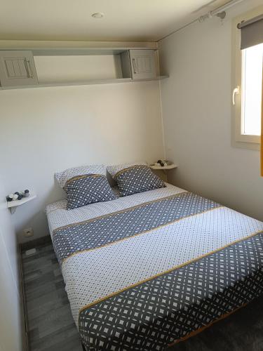 Cette petite chambre comprend un lit avec des draps bleus et blancs. dans l'établissement Le ptit plaisir, à Auch