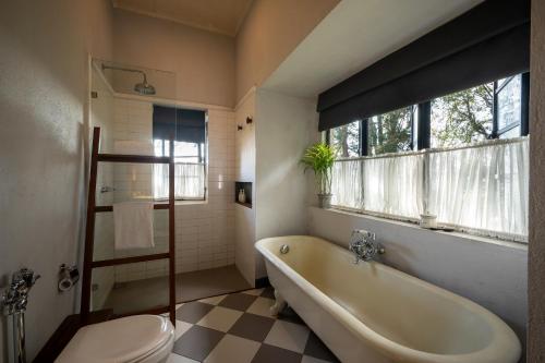 a bathroom with a tub and a toilet and a window at Goatfell - Nuwara Eliya in Kandapola