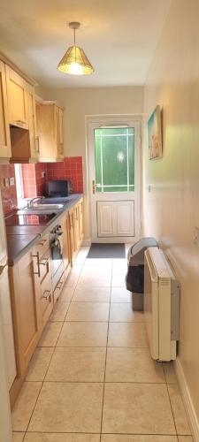 una cucina con armadi in legno e pavimento piastrellato di StaySligo Holiday Homes a Sligo