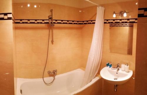 uma casa de banho com uma banheira, um lavatório e um chuveiro em Apartament Niezapominajka em Gdynia