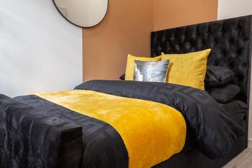 a bedroom with a bed with a yellow and black comforter at The Lanes Deluxe - Rose Platinum Properties in Brighton & Hove