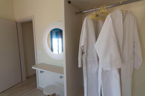 a bathroom with a white robe and a mirror at VILLES RANIA in Karpathos Town
