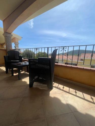 a balcony with chairs and tables and a view of the ocean at Sa Murta Bianca Guesthouse in Budoni