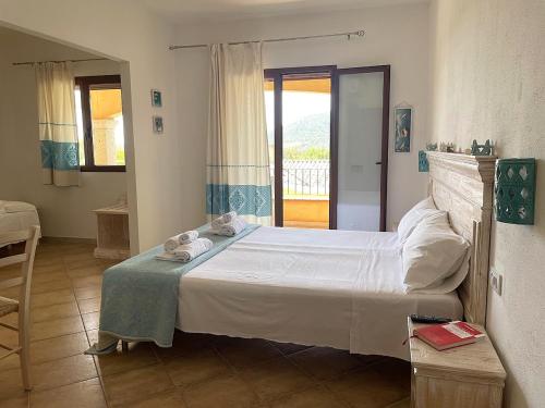 a bedroom with a bed with towels on it at Sa Murta Bianca Guesthouse in Budoni