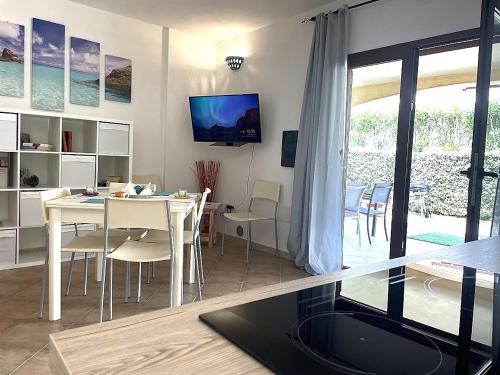 a living room with a table and chairs and a television at Sa Murta Bianca Guesthouse in Budoni