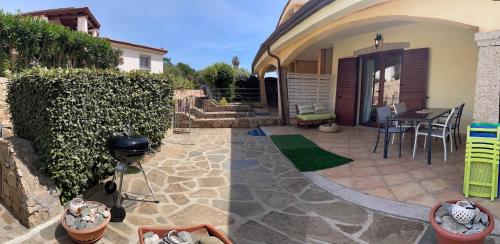 a patio with a grill and a house at Sa Murta Bianca Guesthouse in Budoni