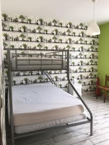 Ce lit se trouve dans un dortoir doté d'un mur de plantes. dans l'établissement Berck-plage appartement, à Berck-sur-Mer