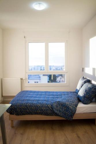 - une chambre avec un lit avec une couette bleue et 2 fenêtres dans l'établissement Le Happy Days -Grand T4 convivial, à Dijon