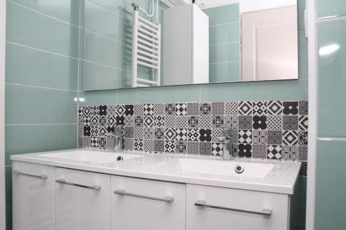 une salle de bain avec un lavabo blanc et un miroir dans l'établissement Le Happy Days -Grand T4 convivial, à Dijon