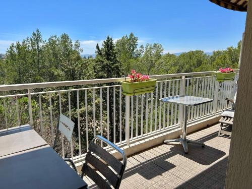 - un balcon avec une table, des chaises et des fleurs dans l'établissement Appartement 72m² à Saint-Raphaël (83), à Saint-Raphaël
