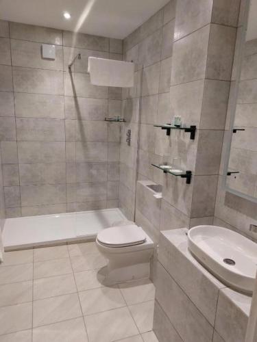 a white bathroom with a toilet and a sink at Owston Hall Hotel in Doncaster