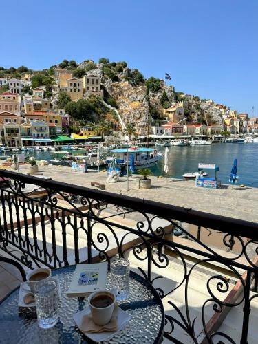 a table with two cups of coffee on a balcony at Amorosa House in Symi