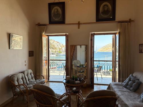 een woonkamer met banken en uitzicht op het water bij Amorosa House in Symi