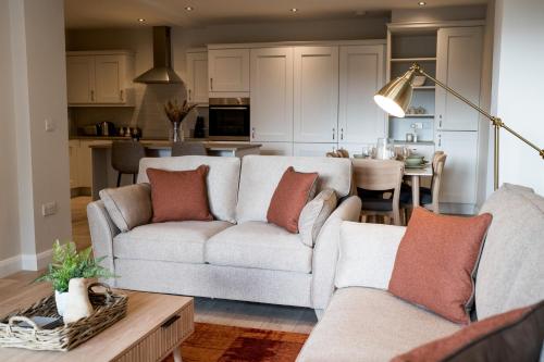 a living room with two couches and a kitchen at No.3 Mill Park a luxury self-catering apartment in Donegal