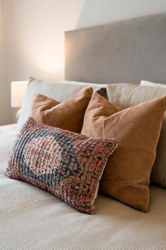 a pile of pillows sitting on a bed at No.3 Mill Park a luxury self-catering apartment in Donegal