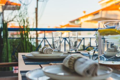 un tavolo con piatti e bicchieri di MainAvenue Palm Seaside a Polykhrono